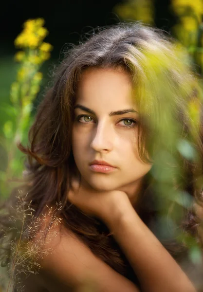 Ritratto di giovane donna su campo di fiori — Foto Stock