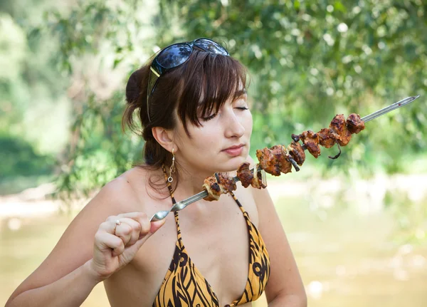 Giovane donna con carne alla griglia — Foto Stock