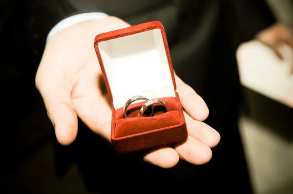 Обручальные кольца в руках жениха — стоковое фото