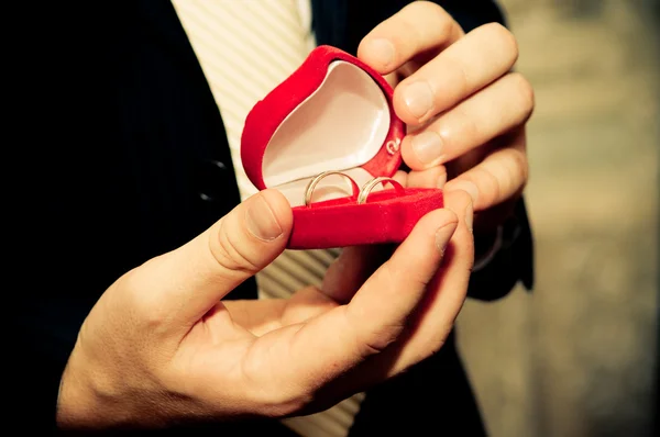 Snubní prsteny v rukou ženicha — Stock fotografie