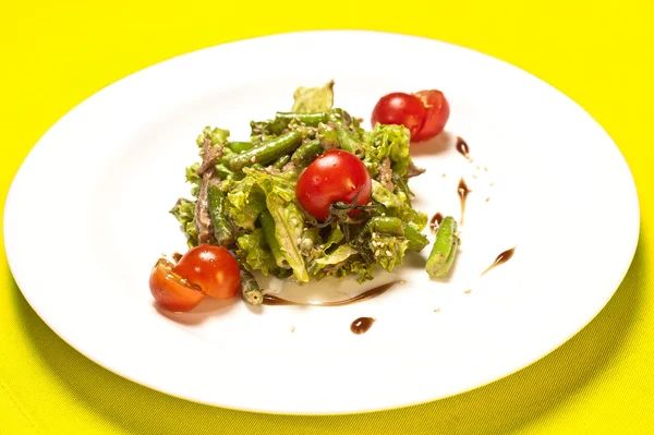 Fechar a chapa de espargos e salada de tomate — Fotografia de Stock