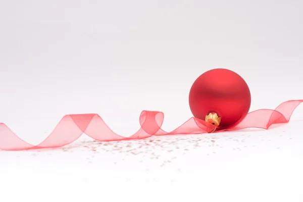 Красная рождественская безделушка и лента — стоковое фото
