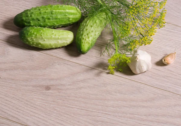 Färska gurkor på ett träbord — Stockfoto