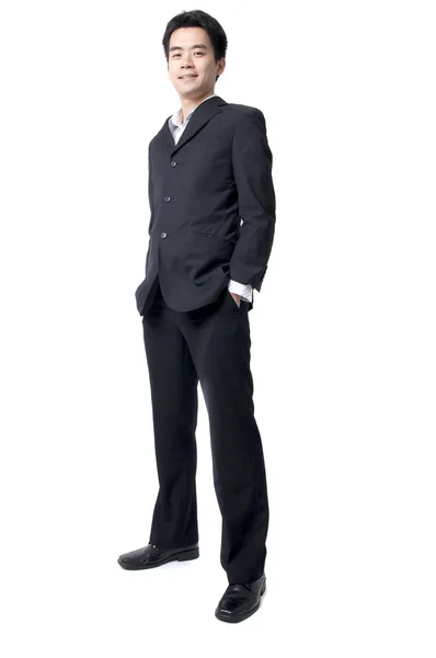 Cuerpo completo de un sonriente joven ejecutivo asiático de pie contra es —  Fotos de Stock