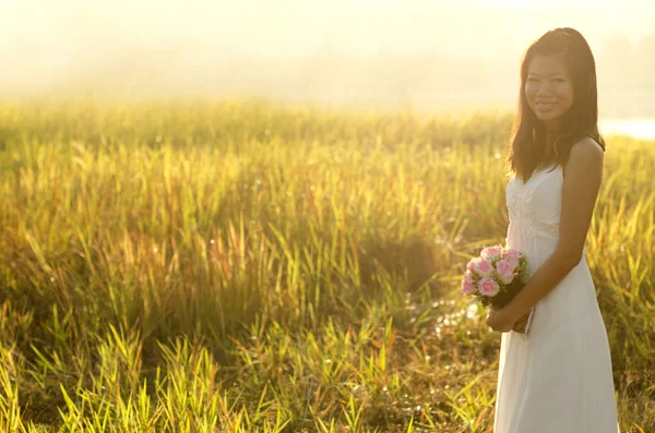 stock image Asian bride at outdoor in a morning surrounding by golden sunlig