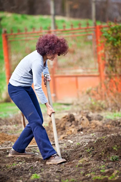Rödhårig ung dam gräva i trädgården — Stockfoto