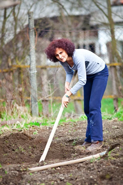 Jonge dame roodharige graven in de tuin — Stockfoto