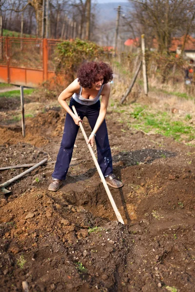 Νεαρή γυναίκα σκάψιμο στον κήπο — Φωτογραφία Αρχείου
