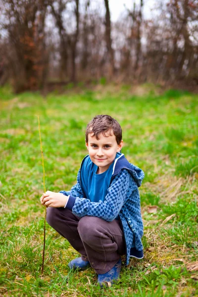 Счастливый мальчик, сидящий на траве — стоковое фото