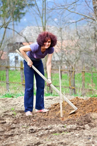 Zrzka mladá dáma kopal v zahradě — Stock fotografie