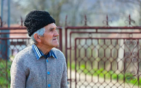Starý muž vedle brány — Stock fotografie