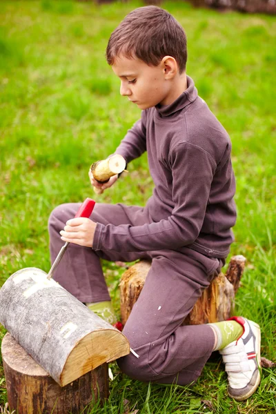 Chłopiec rzeźbienie w Dzienniku z dłutem — Zdjęcie stockowe