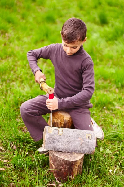 Boy sculpting in a log with a chisel — Stock Photo, Image