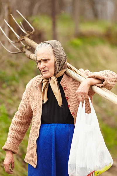 Senior farmer woman with a fork — Stock Photo, Image