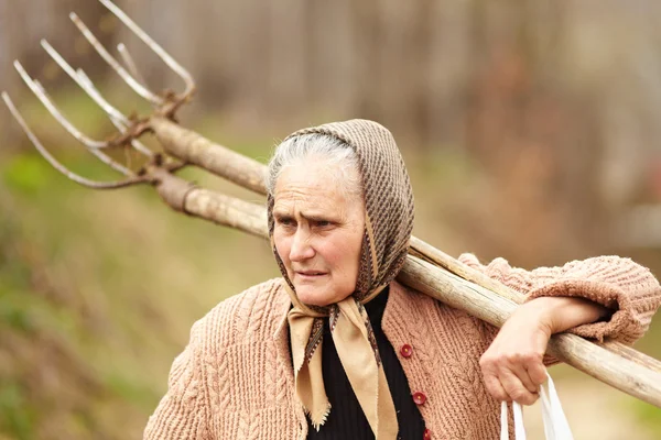 Senior farmer woman with a fork — Stock Photo, Image
