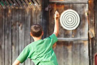 Boy playing darts outdoor clipart