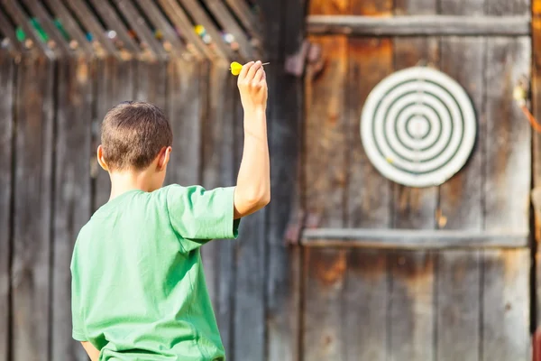 Chlapec hrát šipky venkovní — Stock fotografie