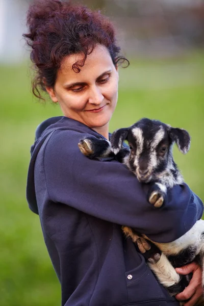 Fiatal nő, baba kecske szabadtéri — Stock Fotó