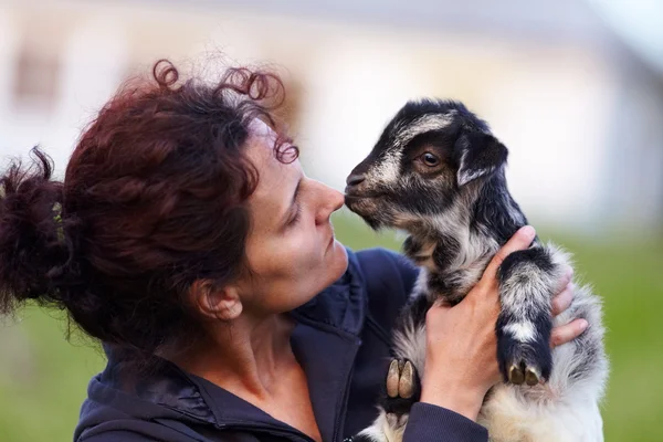 Young woman with baby goat outdoor — Stock Photo, Image