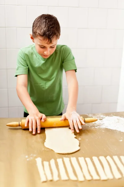 Хлопчик готує печиво або хліб — стокове фото