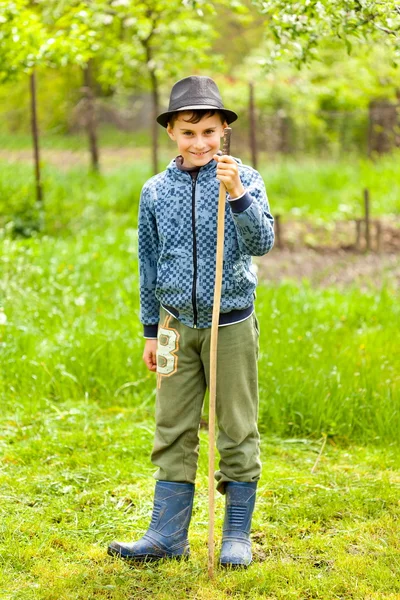 Мальчик в шляпе и сапогах на открытом воздухе — стоковое фото