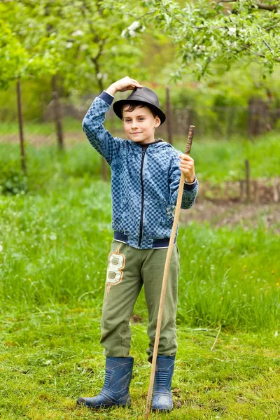 Kleiner Junge mit Hut und Stiefeln draußen — Stockfoto