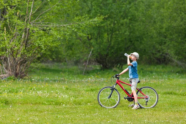 모자에 자전거를 타는 소년 — 스톡 사진