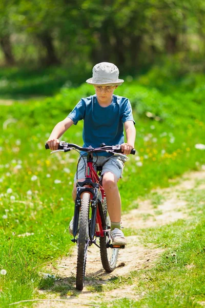 自転車に乗る帽子をかぶった少年 — ストック写真