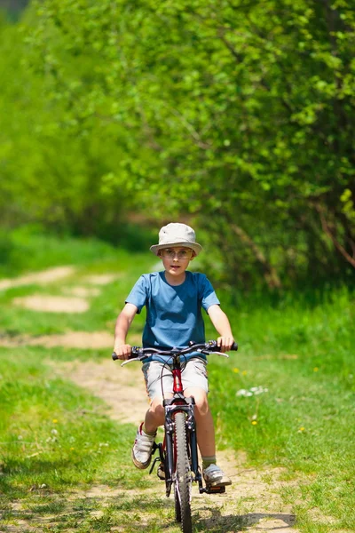 戴着帽子骑自行车的男孩 — 图库照片