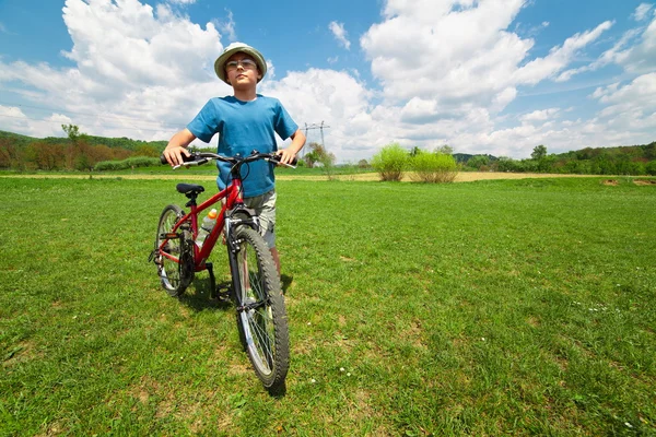 Menino com chapéu andando de bicicleta — Fotografia de Stock