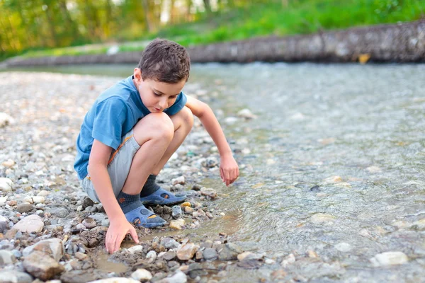 Gyermek játszik egy folyó partján — Stock Fotó