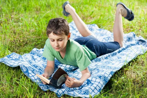 Gyermek olvasó egy könyv szabadtéri — Stock Fotó