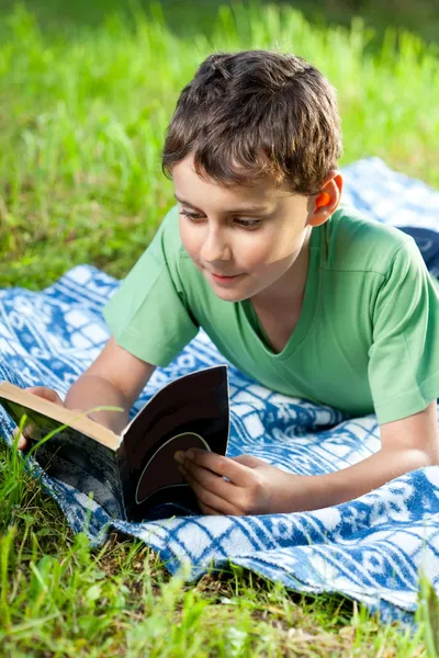 Ребенок читает книгу под открытым небом — стоковое фото