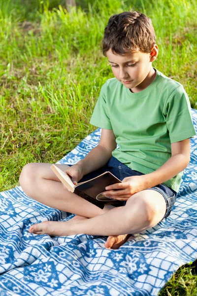 Gyermek olvasó egy könyv szabadtéri — Stock Fotó