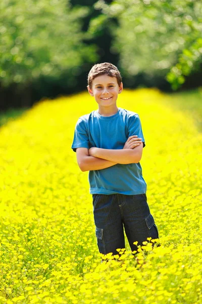 Nettes Kind in einem Blumenfeld — Stockfoto