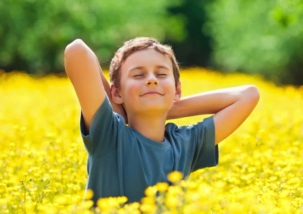 Nettes Kind in einem Blumenfeld — Stockfoto