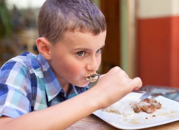 Niño comiendo en un restaurante — Foto de Stock