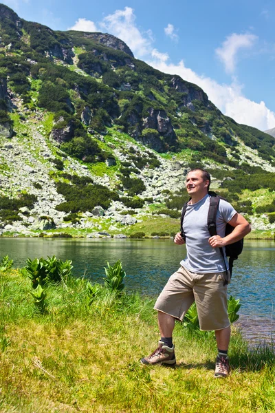 Alpinista com mochila caminhando para as montanhas — Fotografia de Stock