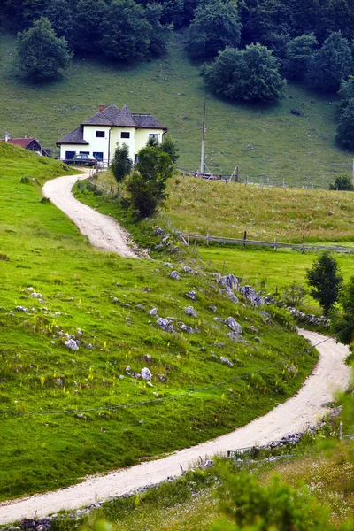 Дорога и дом на горе — стоковое фото