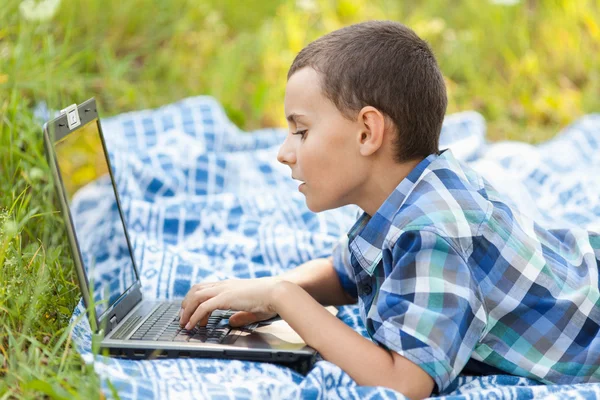 Menino usando laptop ao ar livre — Fotografia de Stock