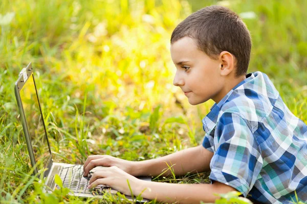 Pojke med laptop utomhus — Stockfoto