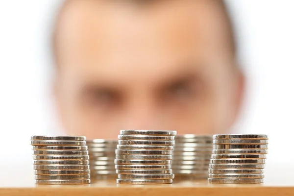 Affärsman tittar på högar av pennies — Stockfoto