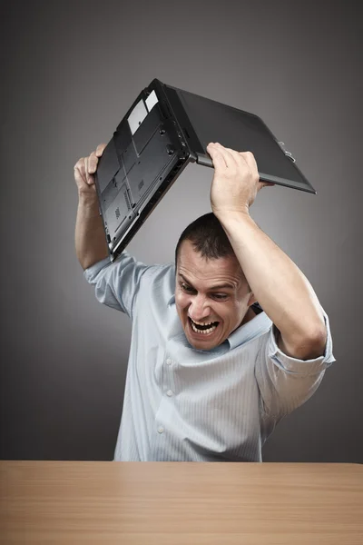 Angry businessman smashing his laptop — Stock Photo, Image