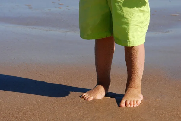 Jambes d'une petite fille sur la plage — Photo
