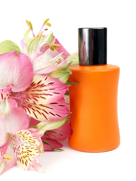 Liten flaska med en parfym vätska och blommor — Stockfoto