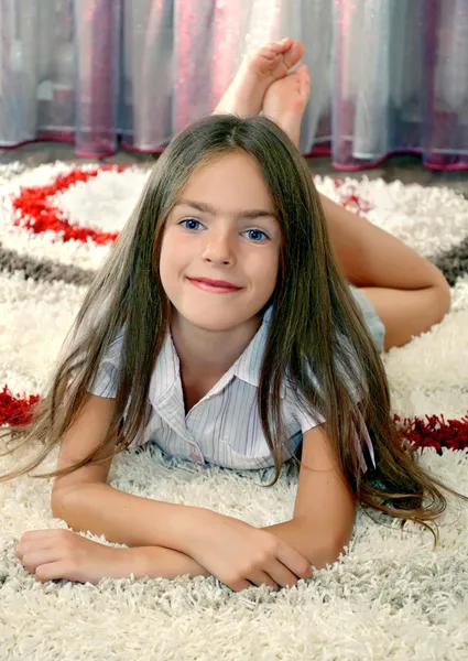 Meisje liggend op een tapijt — Stockfoto
