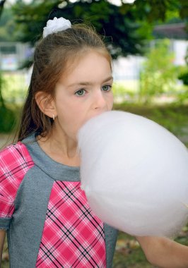 Girl eating sweet cotton wool clipart