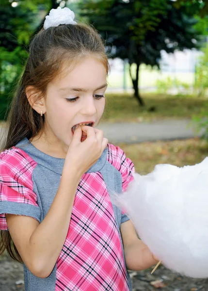 Girl eating sweet cotton wool — Stock Photo, Image