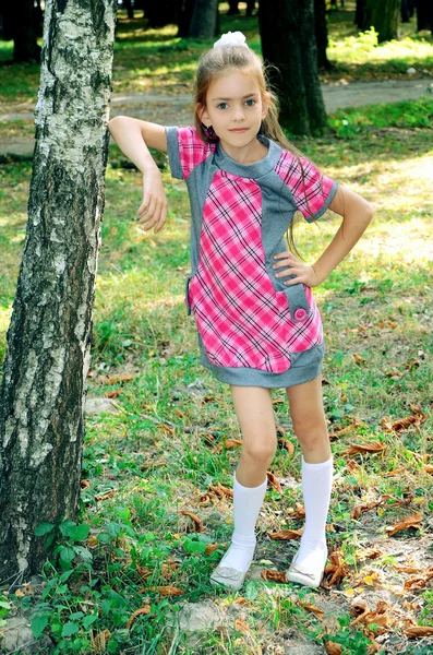 Dívka stojící poblíž stromu — Stock fotografie