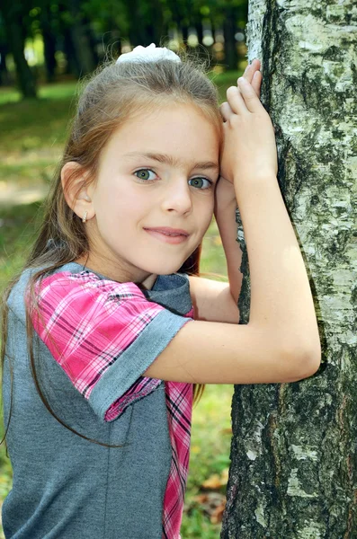 Girl standing near tree — Stock Photo, Image